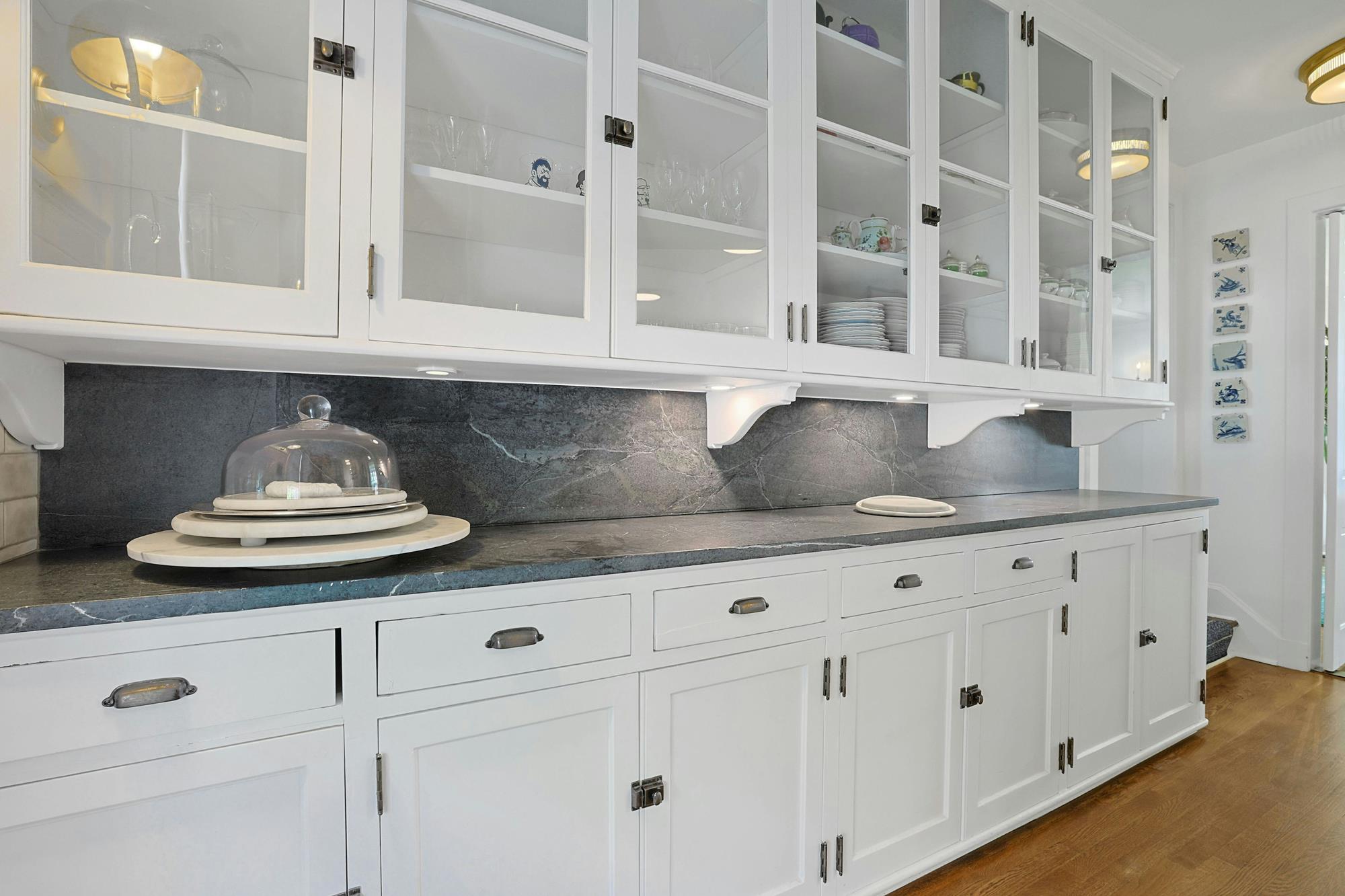 Second view of the kitchen showing a river-facing window and built-in glass cabinetry.